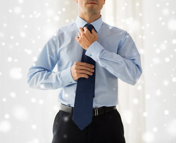 Close up de homem na camisa ajustando gravata no pescoço — Fotografia de Stock