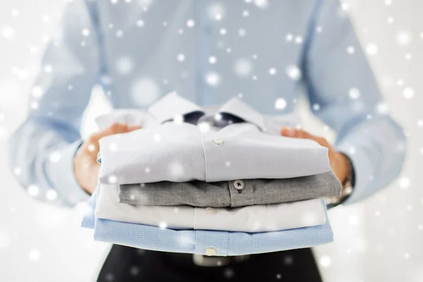 Close up of businessman holding folded shirts — Stock Photo, Image