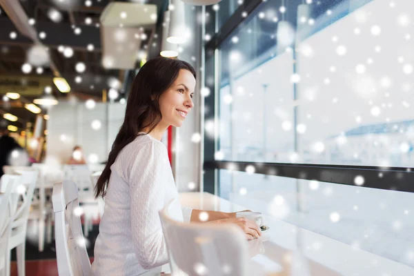 Lächelnde junge Frau trinkt Kaffee im Café — Stockfoto