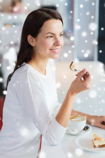 Lächelnde junge Frau mit Kuchen und Kaffee im Café — Stockfoto