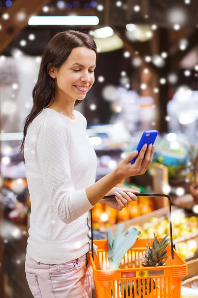 Glückliche Frau mit Korb und Smartphone auf dem Markt — Stockfoto