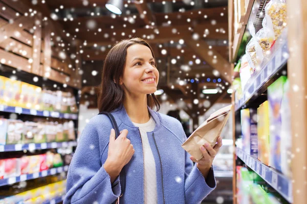 Mulher feliz escolhendo e comprando alimentos no mercado — Fotografia de Stock