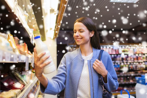 Femme heureuse tenant bouteille de lait dans le marché — Photo