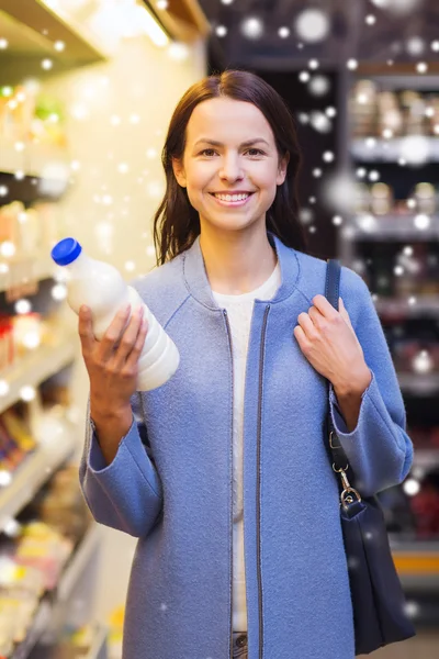 Щаслива жінка тримає пляшку молока на ринку — стокове фото