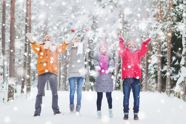 Grupo de amigos felices jugando con nieve en el bosque — Foto de Stock