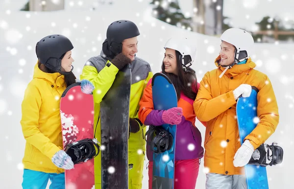 Happy friends in helmets with snowboards talking — Stock Photo, Image