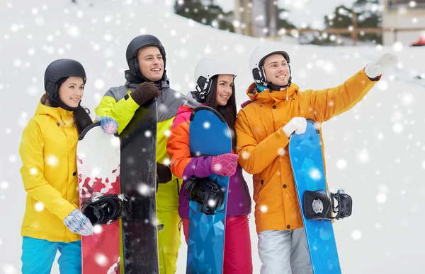 Happy friends in helmets with snowboards — Stock Photo, Image