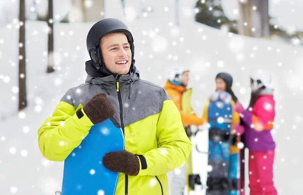 Glada vänner i hjälmar med snowboard — Stockfoto