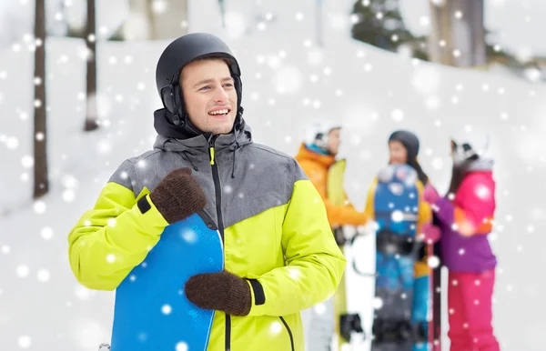 Glückliche Freunde in Helmen mit Snowboards — Stockfoto