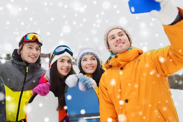 Amigos felices con tablas de snowboard y smartphone —  Fotos de Stock