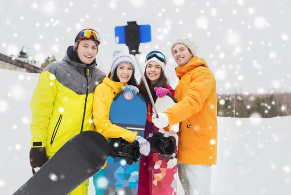 Happy friends with snowboards and smartphone — Stock Photo, Image