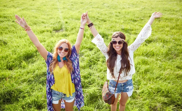 Smiling young hippie women dancing on green field — Stok fotoğraf