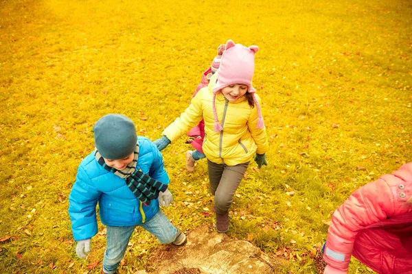 Группа счастливых детей, веселящихся в осеннем парке — стоковое фото