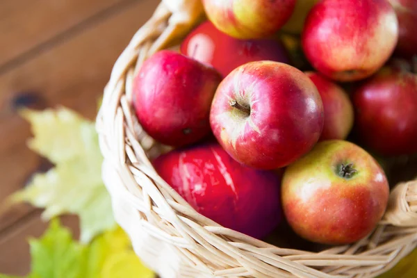Fermer le panier avec des pommes sur une table en bois — Photo