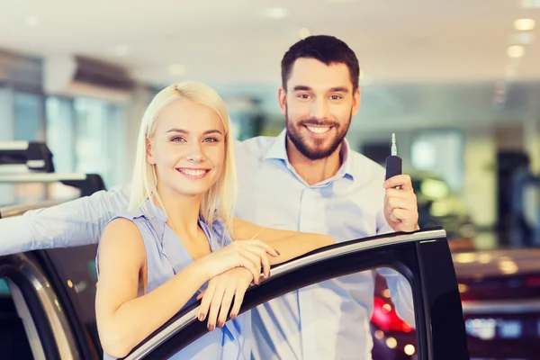 Feliz pareja comprando coche en auto show o salón — Foto de Stock
