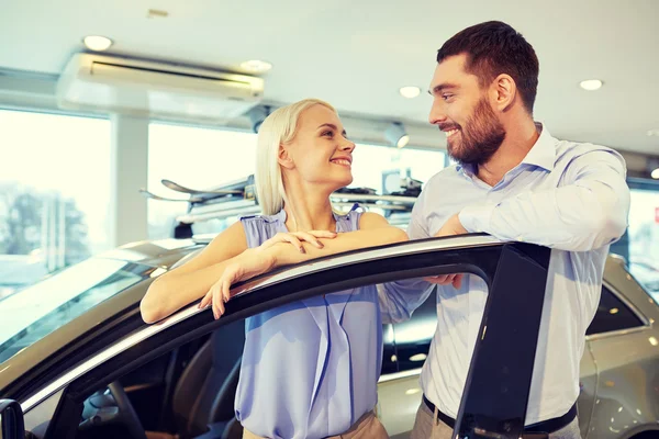 Happy couple buying car in auto show or salon — Stock Photo, Image
