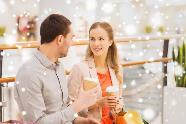 Happy couple with shopping bags drinking coffee — Stock Photo, Image