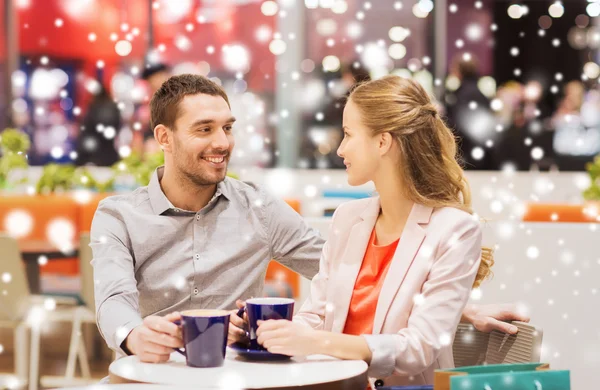 Glückliches Paar mit Einkaufstüten beim Kaffeetrinken — Stockfoto