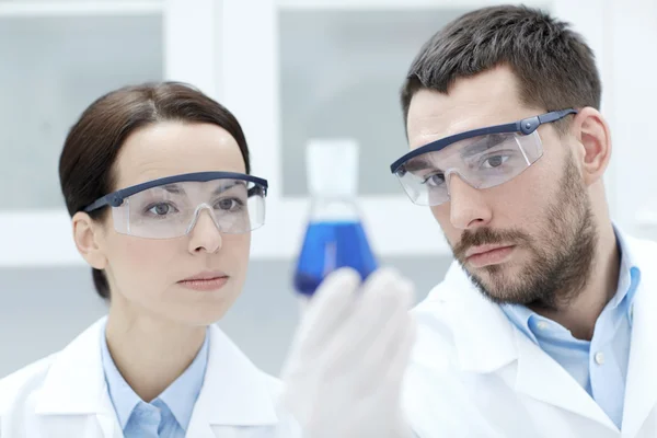 Young scientists making test or research in lab — Stock Photo, Image