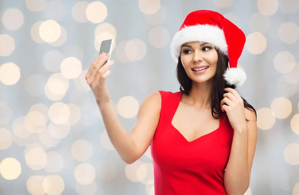 Woman in santa hat taking selfie by smartphone — Stock Photo, Image