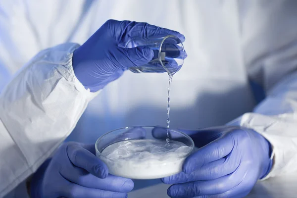 Close up of scientists hands with chemicals in lab — Stock Photo, Image