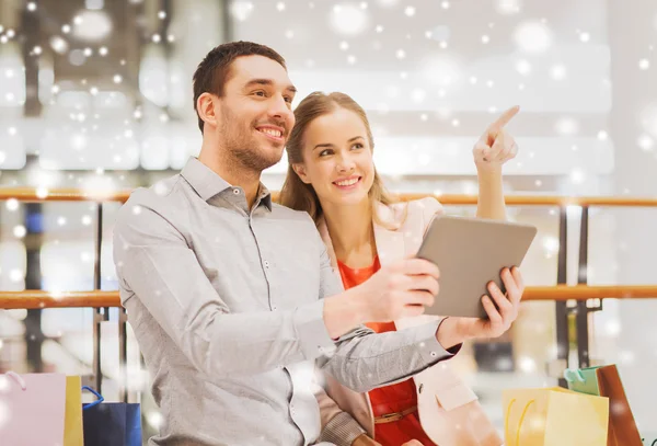 Par med TabletPC och påsar i gallerian — Stockfoto