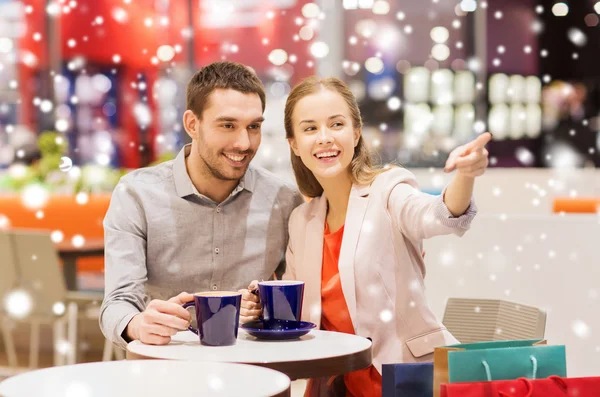 Coppia felice con borse della spesa bere caffè — Foto Stock