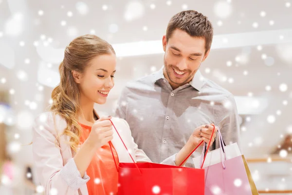 Feliz pareja joven con bolsas de compras en el centro comercial —  Fotos de Stock