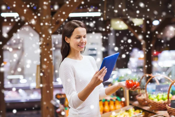 Femme heureuse avec panier et tablette pc dans le marché — Photo