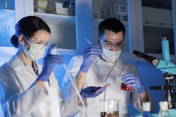 Perto de cientistas que fazem testes em laboratório — Fotografia de Stock