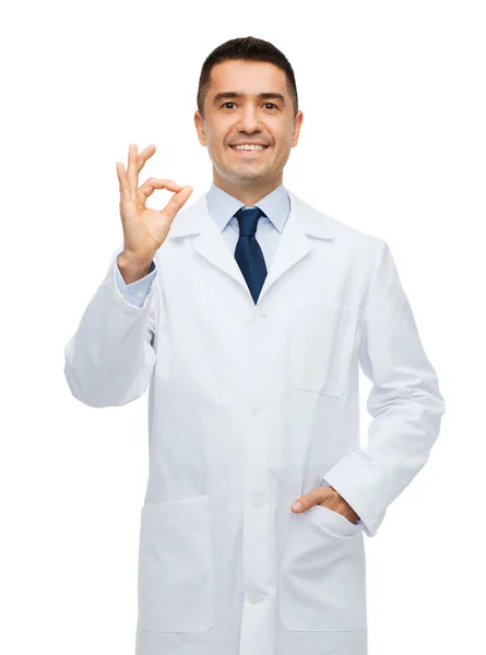 Smiling doctor in white coat showing ok hand sign — Stock fotografie