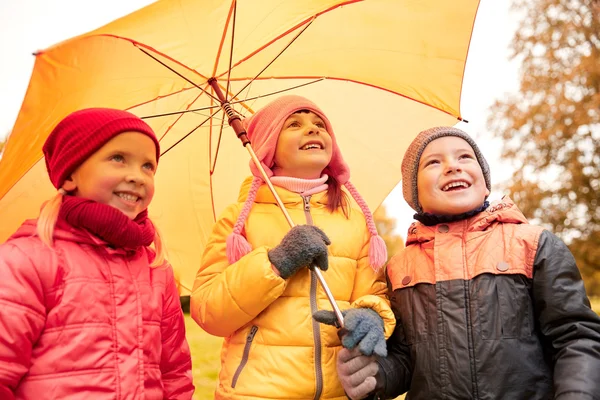 Щасливі діти з парасолькою в осінньому парку — стокове фото