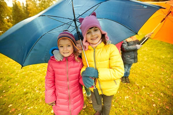 Happy children with umbrella in autumn park — Zdjęcie stockowe