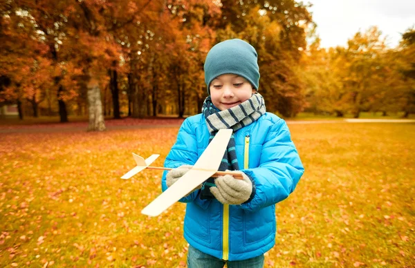 Menino feliz brincando com avião de brinquedo ao ar livre — Fotografia de Stock