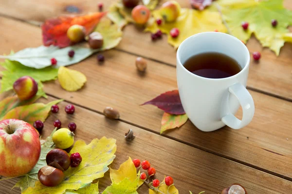 Primer plano de la taza de té en la mesa con hojas de otoño — Foto de Stock