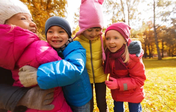 Grupp av glada barn kramas i höst park — Stockfoto