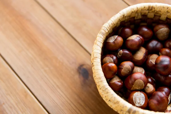 Close-up de castanhas em cesta na mesa de madeira — Fotografia de Stock