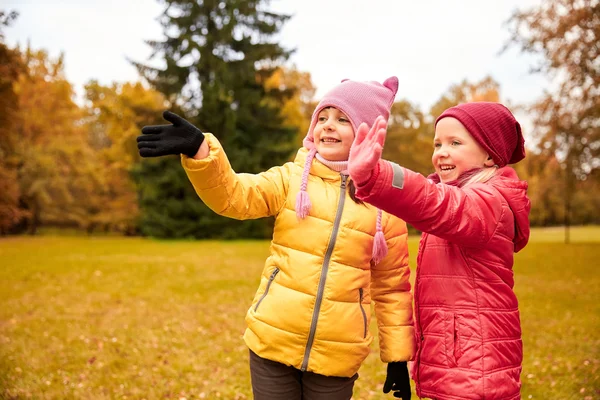 Dos niñas felices saludando mano en el parque de otoño —  Fotos de Stock