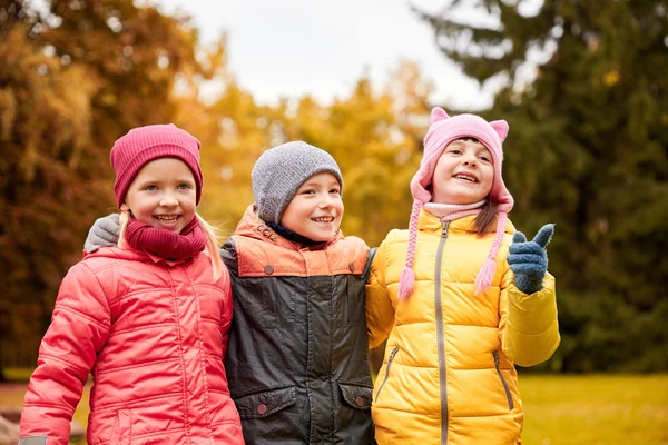 Gruppo di bambini felici che si abbracciano nel parco autunnale — Foto Stock