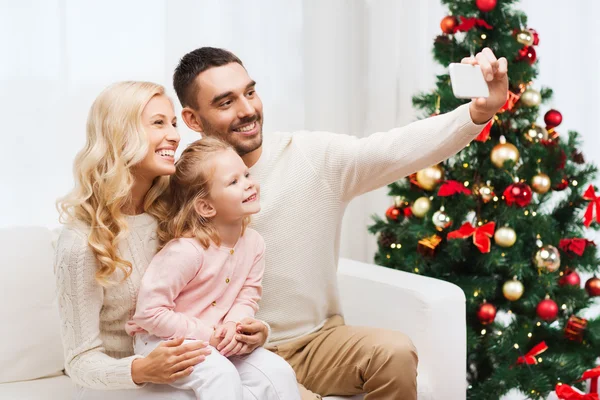 Family taking selfie with smartphone at christmas — Stock Photo, Image