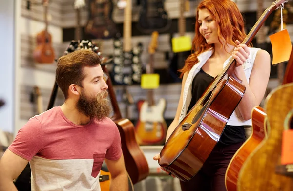 Couple of musicians with guitar at music store — Stock Photo, Image