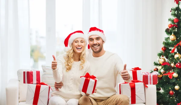 Casal feliz com presentes de Natal e polegares para cima — Fotografia de Stock