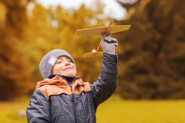 Menino feliz brincando com avião de brinquedo ao ar livre — Fotografia de Stock