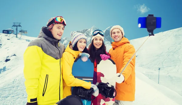 Happy přátelé se snowboardy a smartphone — Stock fotografie