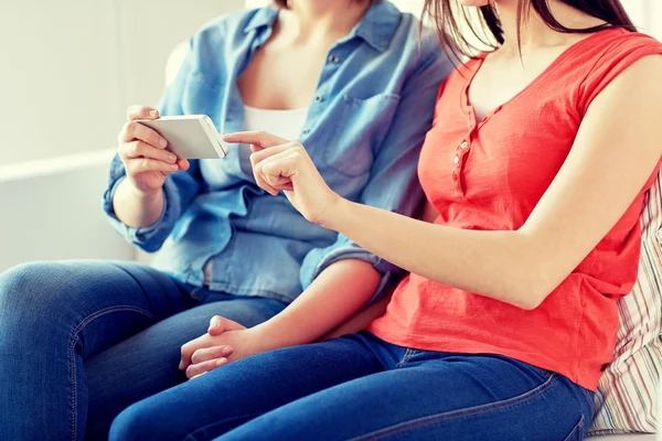 Close up of lesbian couple with smartphone at home — Stock Photo, Image