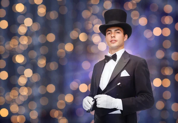 Magician in top hat with magic wand — Stock Photo, Image