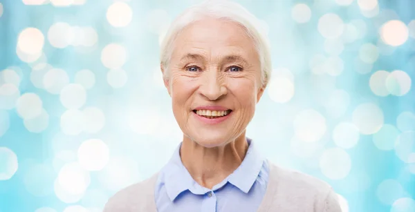 Happy senior woman face over blue lights — Stock Fotó