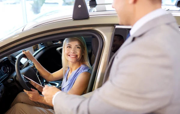 Šťastná žena s prodejci aut v autosalonu nebo salónek — Stock fotografie