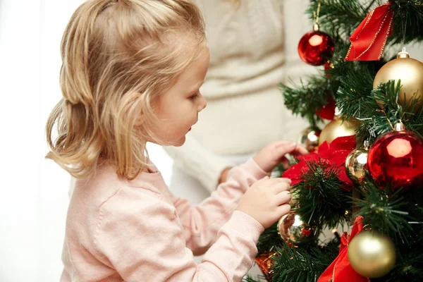 Dívka zdobení vánoční stromeček doma — Stock fotografie
