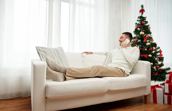 Uomo che chiama su smartphone a casa per Natale — Foto Stock